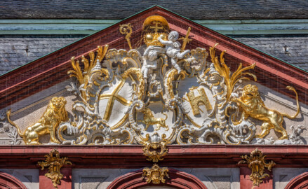 Schloss Bruchsal - Von Außen - Hauptbau - Von Osten / Hofseite - Zentrales Giebelfeld - Unten: Familienwappen des Kardinals Schönborn, links: Wappen des Hochstift Speyer, rechts: Wappen der Propstei Weißenburg - Inschrift im Giebelfeld, unten rechts "renoviert 1902 1936", unten links "rest. 1954" - Stuck ursprünglich von Johann Michael Feichtmayr (aufgenommen im April 2018, um die Mittagszeit) Schloss Bruchsal - Von Außen - Hauptbau - Von Osten / Hofseite - Zentrales Giebelfeld - Unten: Familienwappen des Kardinals Schönborn, links: Wappen des Hochstift Speyer, rechts: Wappen der Propstei Weißenburg - Inschrift im Giebelfeld, unten rechts "renoviert 1902 1936", unten links "rest. 1954" - Stuck ursprünglich von Johann Michael Feichtmayr (aufgenommen im April 2018, um die Mittagszeit)