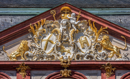 Schloss Bruchsal - Von Außen - Hauptbau - Von Osten / Hofseite - Zentrales Giebelfeld - Unten: Familienwappen des Kardinals Schönborn, links: Wappen des Hochstift Speyer, rechts: Wappen der Propstei Weißenburg - Inschrift im Giebelfeld, unten rechts "renoviert 1902 1936", unten links "rest. 1954" - Stuck ursprünglich von Johann Michael Feichtmayr (aufgenommen im April 2018, um die Mittagszeit) Schloss Bruchsal - Von Außen - Hauptbau - Von Osten / Hofseite - Zentrales Giebelfeld - Unten: Familienwappen des Kardinals Schönborn, links: Wappen des Hochstift Speyer, rechts: Wappen der Propstei Weißenburg - Inschrift im Giebelfeld, unten rechts "renoviert 1902 1936", unten links "rest. 1954" - Stuck ursprünglich von Johann Michael Feichtmayr (aufgenommen im April 2018, um die Mittagszeit)