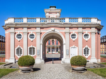 Schloss Bruchsal - Torwachtgebäude / Schlosswachthaus - Von Außen - Von Osten - Blick von der Schönbornstraße auf die Ostfassade des Torwachtgebäudes und hinter dem Durchgang auf die Ostfassade des Hauptbaus (aufgenommen im April 2018, um die Mittagszeit)