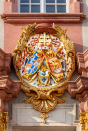 Schloss Bruchsal - Hofkirche - Von Norden / Hofseite - Mittelrisalit - Prunkwappen von Kardinal Graf Damian Hugo von Schönborn  - Wappenschild links: je zwei Felder für das Hochstift Speyer und die Propstei Weißenburg, Wappenschild unten: Deutschordens-Würden (Landkomtur des Deutschen Ordens in Alden-Biesen (oben) und  Marburg (unten)), Wappenschild rechts: Familien- / Stammwappen von Schönborn (aufgenommen im Mai 2018, am Vormittag)