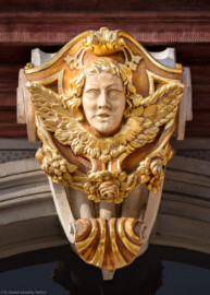 Schloss Bruchsal - Hofkirche - Von Norden / Hofseite - Nordportal - Volute / Kartusche mit Kopf (aufgenommen im Mai 2018, am Vormittag)