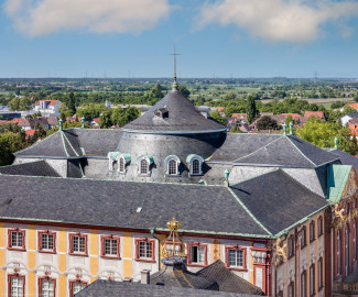 Schloss Bruchsal - Von Außen - Hauptbau - Von Oben - Von Süden - Blick vom Kirchturm nach Norden auf die Südfassade, das Dach und die Kuppel des Hauptbaus (aufgenommen im Mai 2018, am späten Nachmittag) Schloss Bruchsal - Von Außen - Hauptbau - Von Oben - Von Süden - Blick vom Kirchturm nach Norden auf die Südfassade, das Dach und die Kuppel des Hauptbaus (aufgenommen im Mai 2018, am späten Nachmittag)