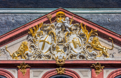 Schloss Bruchsal - Von Außen - Hauptbau - Hofseite - Von Osten - Zentrales Giebelfeld - Unten: Familienwappen des Kardinals Schönborn, links: Wappen des Hochstift Speyer, rechts: Wappen der Propstei Weißenburg - Inschrift im Giebelfeld, unten rechts "renoviert 1902 1936", unten links "rest. 1954" - Stuck ursprünglich von Johann Michael Feichtmayr (aufgenommen im Mai 2018, am Vormittag) Schloss Bruchsal - Von Außen - Hauptbau - Hofseite - Von Osten - Zentrales Giebelfeld - Unten: Familienwappen des Kardinals Schönborn, links: Wappen des Hochstift Speyer, rechts: Wappen der Propstei Weißenburg - Inschrift im Giebelfeld, unten rechts "renoviert 1902 1936", unten links "rest. 1954" - Stuck ursprünglich von Johann Michael Feichtmayr (aufgenommen im Mai 2018, am Vormittag)