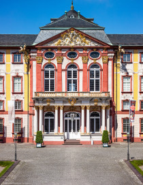 Schloss Bruchsal - Hauptbau - Von Außen / Von Osten / Hofseite - Blick vom Balkon des Torwachtgebäudes auf die Ostfassade mit dem Mittelrisalit, dem Balkon, dem Fürstensaal und dem Dreiecksgiebel (aufgenommen im Mai 2018, um die Mittagszeit) Schloss Bruchsal - Hauptbau - Von Außen / Von Osten / Hofseite - Blick vom Balkon des Torwachtgebäudes auf die Ostfassade mit dem Mittelrisalit, dem Balkon, dem Fürstensaal und dem Dreiecksgiebel (aufgenommen im Mai 2018, um die Mittagszeit)
