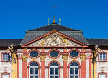 Schloss Bruchsal - Hauptbau - Von Außen / Von Osten / Hofseite - Blick vom Ehrenhof auf den oberen Teil des Mittelrisalits der Ostfassade und auf den Dreiecksgiebel mit dem Wappen (unten: Familienwappen des Kardinals Schönborn, links: Wappen des Hochstift Speyer, rechts: Wappen der Propstei Weißenburg) (aufgenommen im Juni 2018, am Vormittag) Schloss Bruchsal - Hauptbau - Von Außen / Von Osten / Hofseite - Blick vom Ehrenhof auf den oberen Teil des Mittelrisalits der Ostfassade und auf den Dreiecksgiebel mit dem Wappen (unten: Familienwappen des Kardinals Schönborn, links: Wappen des Hochstift Speyer, rechts: Wappen der Propstei Weißenburg) (aufgenommen im Juni 2018, am Vormittag)