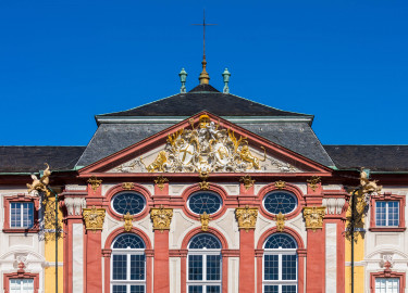 Schloss Bruchsal - Hauptbau - Von Außen / Von Osten / Hofseite - Blick vom Ehrenhof auf den oberen Teil des Mittelrisalits der Ostfassade und auf den Dreiecksgiebel mit dem Wappen (unten: Familienwappen des Kardinals Schönborn, links: Wappen des Hochstift Speyer, rechts: Wappen der Propstei Weißenburg) (aufgenommen im Juni 2018, am Vormittag) Schloss Bruchsal - Hauptbau - Von Außen / Von Osten / Hofseite - Blick vom Ehrenhof auf den oberen Teil des Mittelrisalits der Ostfassade und auf den Dreiecksgiebel mit dem Wappen (unten: Familienwappen des Kardinals Schönborn, links: Wappen des Hochstift Speyer, rechts: Wappen der Propstei Weißenburg) (aufgenommen im Juni 2018, am Vormittag)