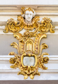 Schloss Bruchsal - Hauptbau / Corps de Logis - Westseite / Gartenseite - Altan, Westseite - Nördliche / linke Kopfkartusche am vorderen Gebälk (aufgenommen im Juni 2018, am späten Vormittag) Schloss Bruchsal - Hauptbau / Corps de Logis - Westseite / Gartenseite - Altan, Westseite - Nördliche / linke Kopfkartusche am vorderen Gebälk (aufgenommen im Juni 2018, am späten Vormittag)