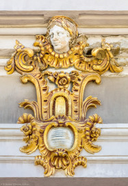 Schloss Bruchsal - Hauptbau / Corps de Logis - Westseite / Gartenseite - Altan, Westseite - Südliche / rechte Kopfkartusche am vorderen Gebälk (aufgenommen im Juni 2018, am späten Vormittag) Schloss Bruchsal - Hauptbau / Corps de Logis - Westseite / Gartenseite - Altan, Westseite - Südliche / rechte Kopfkartusche am vorderen Gebälk (aufgenommen im Juni 2018, am späten Vormittag)