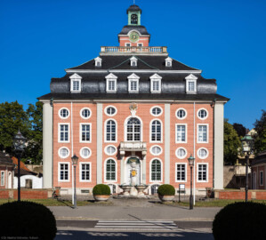 Schloss Bruchsal - Von Außen / Von Westen - Blick vom Durchgang des Torwachtgebäudes auf die Westfassade des Kanzleibaus, davor der Amalienbrunnen, auch „Schneckenbrunnen” genannt (aufgenommen im Juli 2018, am frühen Abend)