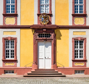 Schloss Bruchsal - Kammerflügel - Von Osten / Hofseite - Ausschnitt aus der östlichen Kopfseite des Kammerflügels (mit dem Portal und dem darüber liegenden Prunkwappen von Kardinal Graf Damian Hugo von Schönborn) (aufgenommen im Juli 2018, am frühen Nachmittag) Schloss Bruchsal - Kammerflügel - Von Osten / Hofseite - Ausschnitt aus der östlichen Kopfseite des Kammerflügels (mit dem Portal und dem darüber liegenden Prunkwappen von Kardinal Graf Damian Hugo von Schönborn) (aufgenommen im Juli 2018, am frühen Nachmittag)