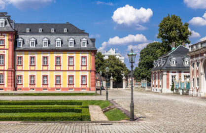 Schloss Bruchsal - Kammerflügel - Von Außen / Von Süden - Blick vom Kirchenflügel auf den östlichen Teil des Kammerflügels (links), das Hofkontrollamt (rechts) und das Torwachtgebäude (ganz rechts) (aufgenommen im Juli 2018, am Nachmittag)