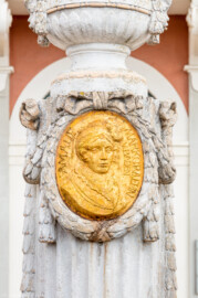 Schloss Bruchsal - Kanzleibau / Amalienbrunnen - Von Westen - Blick vom Vorplatz des Kanzleibaus auf das westliche Medaillon des Amalienbrunnens mit einem Bildnis von Amalie von Hessen-Darmstadt (Brunnen entworfen von Fritz Hirsch, aufgestellt 1912; Medaillon entworfen von Heinrich Ehehalt) (aufgenommen im Juli 2018, am späten Nachmittag) Schloss Bruchsal - Kanzleibau / Amalienbrunnen - Von Westen - Blick vom Vorplatz des Kanzleibaus auf das westliche Medaillon des Amalienbrunnens mit einem Bildnis von Amalie von Hessen-Darmstadt (Brunnen entworfen von Fritz Hirsch, aufgestellt 1912; Medaillon entworfen von Heinrich Ehehalt) (aufgenommen im Juli 2018, am späten Nachmittag)