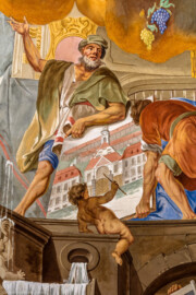 Schloss Bruchsal - Hauptbau / Corps de Logis - Beletage - Kuppelsaal - Kuppelfresko - Ausschnitt aus dem westlichen "irdischen" Bereich - Johann Georg Stahl, Huttens Werkmeister und Architekt; davor ein Putto, der einen Plan Stahls für eine Saline fertigstellt (urspünglich gemalt 1752 von Johannes Zick und Sohn Januarius, originalgetreu rekonstruiert 1966 von Karl Manninger) (aufgenommen im Juli 2018, am frühen Nachmittag)