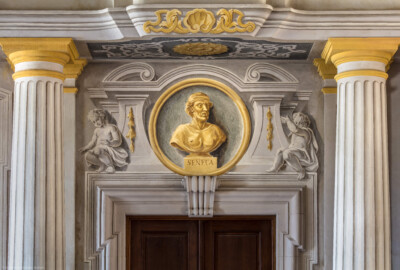 Schloss Bruchsal - Hauptbau / Corps de Logis - Erdgeschoss - Eingangshalle / Intrada - Südwestliche Tür - Blick auf die Türbekrönung mit dem Medaillon des Philosophen Seneca (Malereien ursprünglich von Giovanni Francesco Marchini, restauriert von Hermenegild Peiker) (aufgenommen im Juli 2018, am Nachmittag) Schloss Bruchsal - Hauptbau / Corps de Logis - Erdgeschoss - Eingangshalle / Intrada - Südwestliche Tür - Blick auf die Türbekrönung mit dem Medaillon des Philosophen Seneca (Malereien ursprünglich von Giovanni Francesco Marchini, restauriert von Hermenegild Peiker) (aufgenommen im Juli 2018, am Nachmittag)