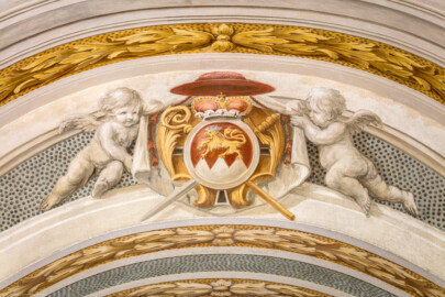 Schloss Bruchsal - Hauptbau / Corps de Logis - Erdgeschoss - Eingangshalle / Intrada - Westseite / Oberhalb Durchgang zur Grotte - Wappenschild von Kardinal Graf Damian Hugo von Schönborn (goldener Löwe über dem silbernen Dreiberg auf rotem Grund mit Kardinalshut, Fürstenkrone, Krummstab und Schwert) (Malerei ursprünglich von Giovanni Francesco Marchini, restauriert von Hermenegild Peiker) (aufgenommen im August 2018, am Nachmittag) Schloss Bruchsal - Hauptbau / Corps de Logis - Erdgeschoss - Eingangshalle / Intrada - Westseite / Oberhalb Durchgang zur Grotte - Wappenschild von Kardinal Graf Damian Hugo von Schönborn (goldener Löwe über dem silbernen Dreiberg auf rotem Grund mit Kardinalshut, Fürstenkrone, Krummstab und Schwert) (Malerei ursprünglich von Giovanni Francesco Marchini, restauriert von Hermenegild Peiker) (aufgenommen im August 2018, am Nachmittag)