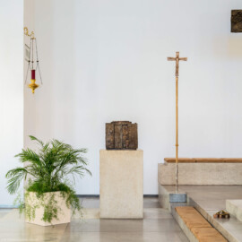 Schloss Bruchsal - Kirchenflügel / Hofkirche / St. Damian und Hugo - Von Innen - Von Norden - Altarbereich, linke / östliche Seite - Tabernakel und Vortragekreuz, beide geschaffen von Fritz Wotruba, sowie Ewiges Licht (aufgenommen im August 2018, am späten Nachmittag)