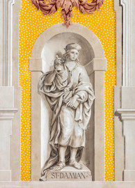 Schloss Bruchsal - Kirchenflügel / Hofkirche / St. Damian und Hugo - Von Westen - Blick vom Kavaliersbau auf die Westfassade der Hofkirche mit der Heiligenfigur von St. Damian (gemalt von Walter Maschke) und der illusionistischen Fassadenmalerei (ursprünglich gemalt von Giovanni Francesco Marchini, zwischen 1732 und 1737) (aufgenommen im August 2018, am späten Nachmittag) Schloss Bruchsal - Kirchenflügel / Hofkirche / St. Damian und Hugo - Von Westen - Blick vom Kavaliersbau auf die Westfassade der Hofkirche mit der Heiligenfigur von St. Damian (gemalt von Walter Maschke) und der illusionistischen Fassadenmalerei (ursprünglich gemalt von Giovanni Francesco Marchini, zwischen 1732 und 1737) (aufgenommen im August 2018, am späten Nachmittag)