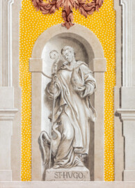 Schloss Bruchsal - Kirchenflügel / Hofkirche / St. Damian und Hugo - Von Westen - Blick vom Kavaliersbau auf die Westfassade der Hofkirche mit der Heiligenfigur von St. Hugo (gemalt von Walter Maschke) und der illusionistischen Fassadenmalerei (ursprünglich gemalt von Giovanni Francesco Marchini, zwischen 1732 und 1737) (aufgenommen im August 2018, am späten Nachmittag)