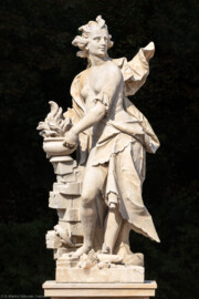 Schloss Bruchsal - Schlossgarten - Hauptachse, Nordseite, 4. Skulptur von Osten - Skulptur "Das Feuer" aus dem Skulpturenensemble "Vier Elemente" (Kopie von Hans Volker Dursy; Original gehauen 1761 von Joachim Günther, befindet sich im Gartensaal des Hauptbaus) (aufgenommen im September 2018, am Nachmittag)