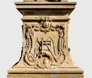 Schloss Bruchsal - Schlossgarten - Hauptachse, Nordseite, 3. Skulptur von Osten - Westseite / linke Seite des Sockels der Skulptur "Das Wasser" aus dem Skulpturenensemble "Vier Elemente" (Kopie; Original gehauen 1761 von Joachim Günther, befindet sich im Gartensaal des Hauptbaus) (aufgenommen im September 2018, am späten Nachmittag)