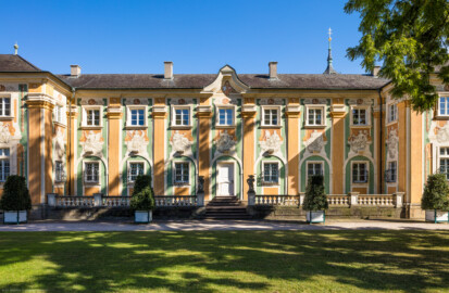 Schloss Bruchsal - Südliche Orangerie / Kavaliersbau - Von Außen - Von Westen - Blick auf den Mittelteil der Westfassade der Orangerie (Fassade der Orangerie ursprünglich gemalt von Giovanni Francesco Marchini, zwischen 1732 und 1737, restauriert von Josef Mariano Kitschker, zwischen 1900 und 1910, erneut restauriert von Klaus Siller (Fassadenmalerei) und  Walter Maschke (Allegorien), 1976) (aufgenommen im September 2018, am  Nachmittag)