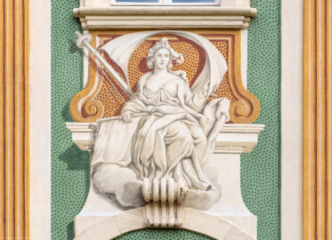 Schloss Bruchsal - Südliche Orangerie / Kavaliersbau - Von Außen - Von Westen - Blick auf die 6. (von Norden/von links gezählt) Allegorie bzw. Figur: vermutlich die "Navigation" (ursprünglich gemalt von Giovanni Francesco Marchini, zwischen 1732 und 1737, restauriert von Josef Mariano Kitschker, zwischen 1900 und 1910, erneut restauriert von Klaus Siller (Fassadenmalerei) und  Walter Maschke (Allegorien), 1976) (aufgenommen im September 2018, am späten Nachmittag)