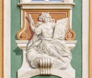 Schloss Bruchsal - Südliche Orangerie / Kavaliersbau - Von Außen - Von Westen - Blick auf die 5. (von Norden/von links gezählt) Allegorie bzw. Figur: vermutlich die "Kartografie" (ursprünglich gemalt von Giovanni Francesco Marchini, zwischen 1732 und 1737, restauriert von Josef Mariano Kitschker, zwischen 1900 und 1910, erneut restauriert von Klaus Siller (Fassadenmalerei) und  Walter Maschke (Allegorien), 1976) (aufgenommen im September 2018, am späten Nachmittag)