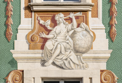 Schloss Bruchsal - Südliche Orangerie / Kavaliersbau - Von Außen - Von Westen - Blick auf die 2. (von Norden/von links gezählt) Allegorie bzw. Figur: vermutlich die "Astronomie" (ursprünglich gemalt von Giovanni Francesco Marchini, zwischen 1732 und 1737, restauriert von Josef Mariano Kitschker, zwischen 1900 und 1910, erneut restauriert von Klaus Siller (Fassadenmalerei) und  Walter Maschke (Allegorien), 1976) (aufgenommen im September 2018, am späten Nachmittag)