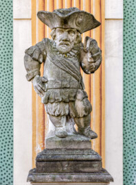 Schloss Bruchsal - Südliche Orangerie / Kavaliersbau, Westseite - Von Westen - Zwerg auf der Balustrade (rechts/südlich der Mitte) (gehauen von Joachim Günther) (aufgenommen im September 2018, am Vormittag)