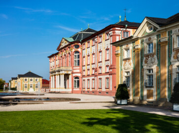 Schloss Bruchsal - Hauptbau / Orangerien - Von Südwest - Blick von der südwestlichen Schlossterrasse auf die Westfassade des Corps de Logis (Mitte), die nördliche (links) und die südliche (rechts) Orangerie  (aufgenommen im September 2018, am späten Nachmittag)