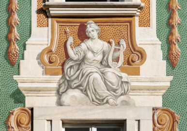 Schloss Bruchsal - Südliche Orangerie / Kavaliersbau - Von Außen - Von Westen - Blick auf die 15. (von Norden/von links gezählt) Allegorie bzw. Figur: vermutlich "Gefährtin der Diana" (Göttin der Jagd) (ursprünglich gemalt von Giovanni Francesco Marchini, zwischen 1732 und 1737, restauriert von Josef Mariano Kitschker, zwischen 1900 und 1910, erneut restauriert von Klaus Siller (Fassadenmalerei) und  Walter Maschke (Allegorien), 1976) (aufgenommen im September 2018, am späten Nachmittag)