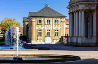 Schloss Bruchsal - Nördliche Orangerie / Nebendienstdienerbau - Von außen / Von Süden - Blick auf die Südfassade der nördlichen Orangerie mit der illusionistischen Fassadenmalerei (ursprünglich gemalt von Giovanni Francesco Marchini, zwischen 1732 und 1737, restauriert von Josef Mariano Kitschker, zwischen 1900 und 1910, erneut restauriert von Klaus Siller (Fassadenmalerei) und  Walter Maschke (Allegorien), 1976) (aufgenommen im Oktober 2018, um die Mittagszeit)