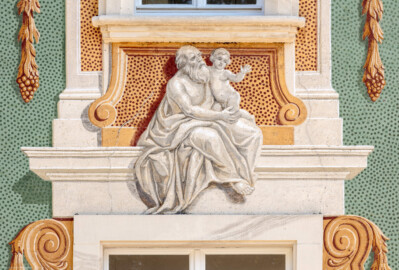 Schloss Bruchsal - Nördliche Orangerie / Nebendienstdienerbau - Von Außen / Von Westen - Blick auf die 15. (ganz rechte) Allegorie/Figur von Norden/von links; vermutlich Darstellung eines der drei Menschenalter: Kindheit (ursprünglich gemalt von Giovanni Francesco Marchini, zwischen 1732 und 1737, restauriert von Josef Mariano Kitschker, zwischen 1900 und 1910, erneut restauriert von Klaus Siller (Fassadenmalerei) und  Walter Maschke (Allegorien), 1976) (aufgenommen im Oktober 2018, am Nachmittag)
