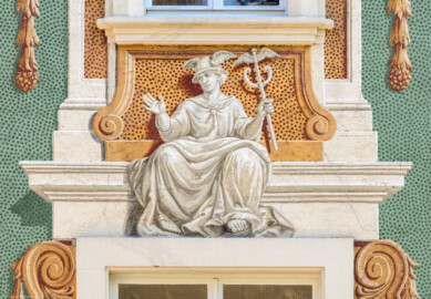 Schloss Bruchsal - Nördliche Orangerie / Nebendienstdienerbau - Von Außen / Von Westen - Blick auf die 3. Allegorie/Figur von Norden/von links; vermutlich Darstellung des Götterboten bzw. Planetengotts Merkur (ursprünglich gemalt von Giovanni Francesco Marchini, zwischen 1732 und 1737, restauriert von Josef Mariano Kitschker, zwischen 1900 und 1910, erneut restauriert von Klaus Siller (Fassadenmalerei) und  Walter Maschke (Allegorien), 1976) (aufgenommen im Oktober 2018, am Nachmittag)