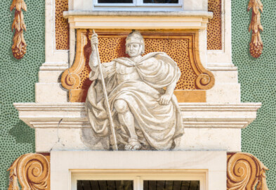 Schloss Bruchsal - Nördliche Orangerie / Nebendienstdienerbau - Von Außen / Von Westen - Blick auf die 2. Allegorie/Figur von Norden/von links; vermutlich Darstellung des Kriegsgotts / Planetengotts Mars (ursprünglich gemalt von Giovanni Francesco Marchini, zwischen 1732 und 1737, restauriert von Josef Mariano Kitschker, zwischen 1900 und 1910, erneut restauriert von Klaus Siller (Fassadenmalerei) und  Walter Maschke (Allegorien), 1976) (aufgenommen im Oktober 2018, am Nachmittag)