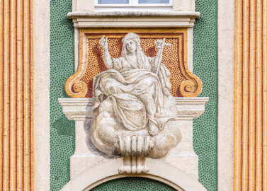 Schloss Bruchsal - Nördliche Orangerie / Nebendienstdienerbau - Von Außen / Von Westen - Blick auf die 8. (mittlere) Allegorie/Figur von Norden/von links; vermutlich Darstellung einer der drei göttlichen Tugenden bzw. theologischen Tugenden: Glaube (ursprünglich gemalt von Giovanni Francesco Marchini, zwischen 1732 und 1737, restauriert von Josef Mariano Kitschker, zwischen 1900 und 1910, erneut restauriert von Klaus Siller (Fassadenmalerei) und  Walter Maschke (Allegorien), 1976) (aufgenommen im Oktober 2018, am Nachmittag)
