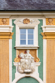 Schloss Bruchsal - Nördliche Orangerie / Nebendienstdienerbau - Von Außen / Von Westen - Blick auf die die Westfassade mit der Illusionsmalerei im Bereich der 10. Allegorie/Figur (von Norden/von links gezählt) (ursprünglich gemalt von Giovanni Francesco Marchini, zwischen 1732 und 1737, restauriert von Josef Mariano Kitschker, zwischen 1900 und 1910, erneut restauriert von Klaus Siller (Fassadenmalerei) und  Walter Maschke (Allegorien), 1976) (aufgenommen im Oktober 2018, am Nachmittag)