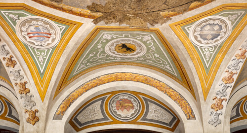 Schloss Bruchsal - Hauptbau - Erdgeschoss - Gartensaal / Sala Terrena - Östlicher Haupteingang - Blick nach oben auf den unteren Teil des Gewölbes mit Wappenfeldern und auf das Sturzfeld über der Türe mit dem Wappen von Kardinal Graf Damian Hugo von Schönborn (Malereien ursprünglich von Giovanni Francesco Marchini, zwischen 1731 und 1736, restauriert von der Restauratoren-Arbeitsgemeinschaft Alfred Panowsky / Klaus Siller, 1982 bis 1986) (aufgenommen im Oktober 2018, am Nachmittag) Schloss Bruchsal - Hauptbau - Erdgeschoss - Gartensaal / Sala Terrena - Östlicher Haupteingang - Blick nach oben auf den unteren Teil des Gewölbes mit Wappenfeldern und auf das Sturzfeld über der Türe mit dem Wappen von Kardinal Graf Damian Hugo von Schönborn (Malereien ursprünglich von Giovanni Francesco Marchini, zwischen 1731 und 1736, restauriert von der Restauratoren-Arbeitsgemeinschaft Alfred Panowsky / Klaus Siller, 1982 bis 1986) (aufgenommen im Oktober 2018, am Nachmittag)