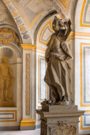 Schloss Bruchsal - Hauptbau - Erdgeschoss - Gartensaal / Sala Terrena - Skulptur im Südwesten - Skulptur "Das Feuer" aus dem Skulpturenensemble "Vier Elemente", gehauen von Joachim Günther (Original; eine Kopie befindet sich im Schlossgarten) (Malereien ursprünglich von Giovanni Francesco Marchini, zwischen 1731 und 1736, restauriert von der Restauratoren-Arbeitsgemeinschaft Alfred Panowsky / Klaus Siller, 1982 bis 1986) (aufgenommen im November 2018, am frühen Nachmittag)