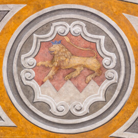Schloss Bruchsal - Hauptbau - Erdgeschoss - Gartensaal / Sala Terrena - Türsturzfeld direkt über der Osttür - 1. Wappen (element), von Kardinal Graf Damian Hugo von Schönborn - Zählung beginnend an der Osttür, dann im Kreis nach Süden (Malereien ursprünglich von Giovanni Francesco Marchini, zwischen 1731 und 1736, restauriert von der Restauratoren-Arbeitsgemeinschaft Alfred Panowsky / Klaus Siller, 1982 bis 1986) (aufgenommen im November 2018, am Nachmittag)
