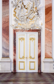 Schloss Bruchsal - Hauptbau - Beletage / Corps de Logis - Kuppelsaal - Von Osten - Blick vom Zentrum des Kuppelsaals auf die Tür zum Marmorsaal, Stuckdraperie oberhalb des Durchgangs (Stuck ursprünglich geschaffen von Johann Michael Feichtmayr) (aufgenommen im Februar 2019, am Nachmittag)