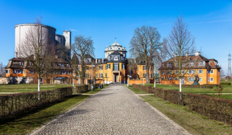 Waghäusel - Eremitage - Von Außen / Von Osten - Blick von der östlichen Friedrich-Hecker-Allee auf das Gesamt-Ensemble, in der Mitte der Zentralbau, links und rechts zwei der Kavalierspavillons, ganz links die riesigen Silos (Ende 2020 abgerissen) der ehemaligen Zuckerfabrik (aufgenommen im März 2019, am Vormittag)