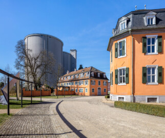 Waghäusel - Eremitage - Von Außen / Von Osten - Blick auf den südwestlichen Kavalierspavillon, den "Fremdenbau" (Mitte), den Hauptbau (rechts) und auf die riesigen Silos (Ende 2020 abgerissen)  der ehemaligen Zuckerfabrik (links) (aufgenommen im März 2019, um die Mittagszeit)