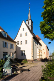 Waghäusel - Wallfahrtskirche - Von Außen / Von Osten - Blick auf die Marienwallfahrtskirche, links das Kloster der Brüder vom gemeinsamen Leben, davor eine Skulptur der Hl. Klara, der Patronin des Klosters (aufgenommen im April 2019, am Vormittag)