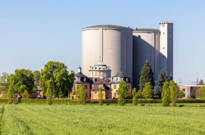 Waghäusel - Eremitage - Von Außen / Von Nordosten - Blick auf das Gesamt-Ensemble: in der Mitte der Zentralbau, davor der nordöstliche Kavalierspavillon, links der südöstliche Kavalierspavillon und ganz hinten die riesigen Silos (Ende 2020 abgerissen) der ehemaligen Zuckerfabrik (aufgenommen im April 2019, am Vormittag)