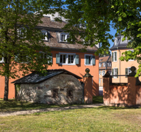 Waghäusel - Eremitage - Von Außen / Von Nordost - Blick auf den südöstlichen Kavalierspavillon (den "Küchenbau"), davor ein altes Steinhaus (aufgenommen im April 2019, am Vormittag)