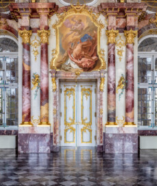 Schloss Bruchsal - Hauptbau / Corps de Logis - Beletage - Marmorsaal / Kaisersaal - Östliche Wand - Von Westen - Blick auf die Tür zum Kuppelsaal, die beidseitigen Doppelsäulen sowie die Supraporte "Sturz der Titanen" (Stuckaturen ursprünglich von Johann Michael Feichtmayr; Supraporte ursprünglich gemalt von Johannes Zick, rekonstruiert von Wolfram Köberl, 1976-1981) (aufgenommen im April 2019, am Nachmittag)