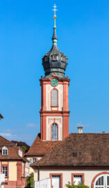 Schloss Bruchsal - Kirchturm - Von Außen / Von Westen - Blick auf den  Kirchturm der Hofkirche, die Hofapotheke (links) sowie den westlichen Bandhof (rechts) (aufgenommen im April 2019, am späten Nachmittag)