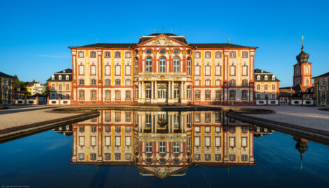 Schloss Bruchsal - Hauptbau - Von Außen - Von Westen / Gartenseite - Blick von der Schlossterrasse auf die Westfassaden des Hauptbaus (Mitte), des Kammerflügels (links), des Kirchenflügels (rechts) sowie auf den Kirchturm (ganz rechts) (aufgenommen im April 2019, am frühen Abend)