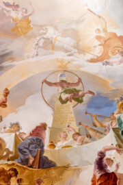 Schloss Bruchsal - Hauptbau / Corps de Logis - Beletage - Marmorsaal / Kaisersaal - Deckenfresko, Innere Zone, nördlich des Zentrums - Von Süden - Im Zentrum: der Weltbaumeister Demogorgon mit Schlangenring als Symbol der Ewigkeit, vor einem Obelisk mit einer Weltkugel oben; darüber: die speyerische "Gnadenjungfrau" Astraia im Tierkreis; oben: der Sonnengott Apoll mit seinem Sonnenwagen über dem  Zodiacus (dem Tierkreis); unten: das ewige Göttermahl im Olymp - Inschrift auf dem Obelisk: "SPIRA HAEC PERPETUO SINE FINE REVOLUITUR ORBE. FELIX SPIRA CUI PRODROMA SPIRA STATUS." / Übersetzung von Barbara Strieder: "Diese Schlangenwindung wird in ewigem Kreislauf ohne Ende in sich selbst zurückgeführt, glückliches Speyer, dessen Wohlstand die im Sinnbild der Schlange gefasste Beständigkeit besitzt"  (Deckenfresko urspünglich gemalt 1754 von Johannes Zick, originalgetreu rekonstruiert 1971 bis 1974 von Wolfram Köberl; Stuck urspünglich von Johann Michael Feuchtmayer dem Jüngeren, rekonstruiert 1962 bis 1969 von Jakob und Josef Schnitzer) (aufgenommen im Mai 2019, am Nachmittag)